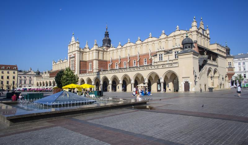 Widok na Sukiennice i plac Rynku ze straganami kwiatów od strony pomnika Mickiewicza
