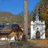 Mały jasny budynek murowanej kaplicy w Parku Zdrojowym. Po lewej willa w stylu szwajcarskim.