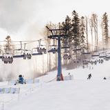 Stacja narciarska z wyciągiem krzesełkowym. Po bokach stoku ustawione armatki śnieżne, które naśnieżają stok.