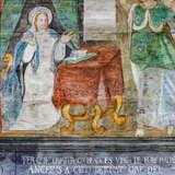 Fresk przedstawiający siedzącą kobietę - świętą przy stole z książką. Obok stołu druga postać świętego.