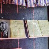 Dwa zeszyty z zapiskami zawieszone na podkładkach w Muzeum Armii Krajowej w Krakowie.