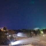 Widok na oświetloną stację narciarską Słotwiny Arena, w tle wyciąg krzesełkowy.